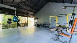 Modern gym with workout equipment and waterfall view in Costa Rica.