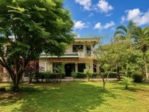 Two-story villa with lush garden and tropical trees in Dominical Costa Rica.