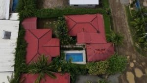 Aerial view of two villas with red roofs, pool, and lush greenery in Dominical, Costa Rica.