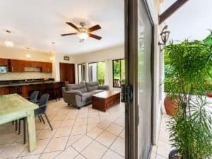 Bright living room with sofa, dining area, and outdoor patio view.