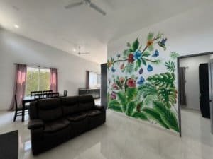 Bright living room with colorful tropical mural and modern furniture.