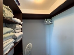 Closet with shelves, clothes, and a fan in a private home in Dominical, Costa Rica.