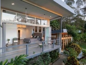 Modern bedroom with panoramic mountain view and balcony in Costa Rica.