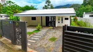 Contemporary single-story house with a metal roof and lush garden in Dominical.