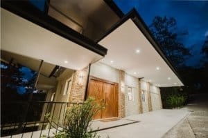 Modern luxury estate entrance with stone accents and wooden door in Dominical.