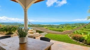 Beautiful view of the ocean and lush greenery from a tropical hacienda patio.
