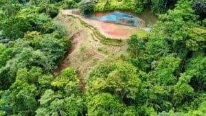 Aerial view of lush land with ocean view and terraced areas in Dominical.