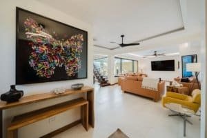 Spacious modern living room with colorful butterfly art and ocean view.