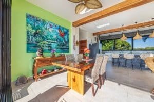 Colorful tropical-themed dining room with wooden furniture and large windows.