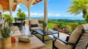 Beautiful covered porch with seating and lush tropical landscape in Dominical.