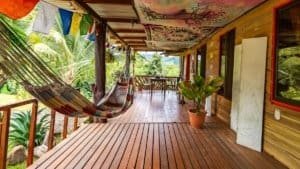 Covered porch with hammock, potted plants, and mountain view in Costa Rica.