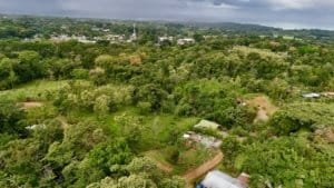 A lush green hillside in Uvita Costa Rica with building plots and dirt roads.