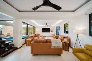 Spacious living room with ocean and jungle views, modern decor, and large windows.