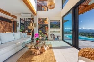 Modern living room with large glass doors, mountain views, and pool access.