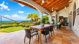 Covered patio with dining area overlooking lush landscape and ocean view in Dominical.