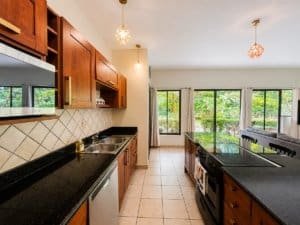 Modern kitchen with wooden cabinets and garden view in Dominical.