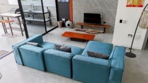 Contemporary living room with blue sofa, TV, and minimalist decor in Dominical.