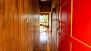 Interior view of a wooden hallway leading to a bright room with a view of nature.