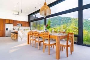 Bright dining space with large windows overlooking lush green mountains in Costa Rica.