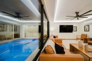 Modern living room with indoor pool, TV, and comfortable seating in Costa Rica.