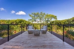 Balcony with two chairs and a table overlooking lush green mountains in Costa Rica.