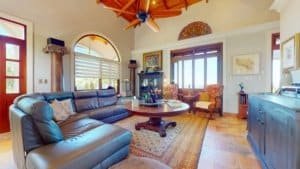 Spacious living room with leather sofa, wooden ceiling, and ocean view.