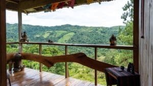 Scenic mountain view from a rustic Costa Rican home with wooden balcony.