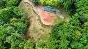 Aerial view of lush land with ocean and white water views in Dominical.