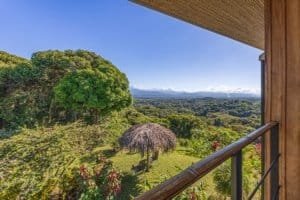 Balcony view of lush green forest and distant mountains in Dominical.