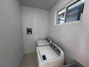 Clean laundry room with washer, dryer, and window in Dominical.