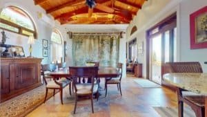 Spacious dining area in a tropical hacienda with white water view and wooden ceiling.