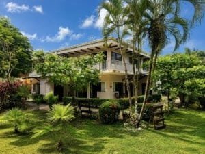 Beautiful garden villa in Dominical, Costa Rica with lush greenery and tropical trees.