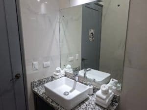Contemporary bathroom with white sink, mirror, and towels in Dominical.