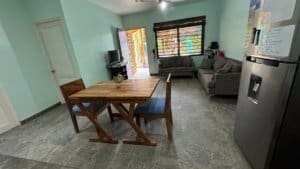 Interior of a Costa Rican home with dining area and sofa, near the beach.