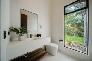 Contemporary bathroom with large window overlooking lush greenery in Dominical.