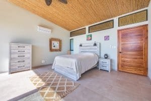 Bright bedroom with wooden ceiling, mountain view, and minimalist decor.