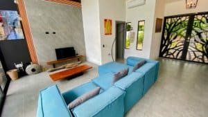 Spacious living room with blue sofa, modern decor, and large windows in Dominical.