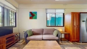 Comfortable living room with sofa, colorful wall art, and large windows in Dominical.