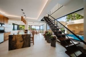 Modern interior with open kitchen, staircase, and pool view in Costa Rica.