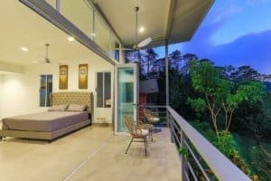 Balcony view from a luxury mountain retreat bedroom overlooking lush forest.