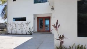 Contemporary home entrance with wooden door and ocean view in Dominical.