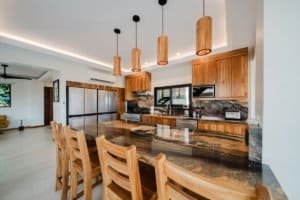 Modern kitchen with wooden cabinets, island, and pendant lighting in Costa Rica estate.