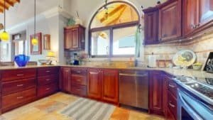 Warm kitchen with wooden cabinets, modern appliances, and natural light.