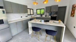 Contemporary kitchen with gray cabinets, marble countertops, and a central island.