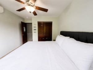 Bright bedroom with ceiling fan and wooden closet in Dominical real estate.
