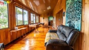 Interior of a wooden mountain home with large windows and comfortable seating.