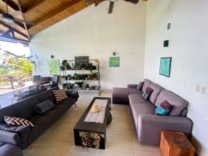Living room with sofas, artwork, and ocean view in Dominical.