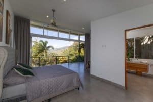 Spacious bedroom with panoramic mountain view and modern decor.