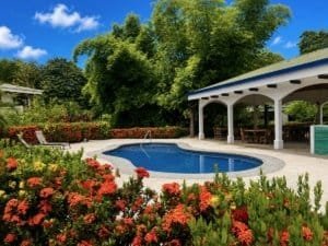 Beautiful pool area with lush garden and shaded seating in Dominical, Costa Rica.