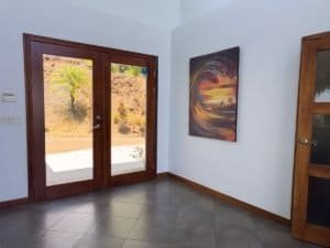 Interior room with sliding glass door and ocean sunset painting.